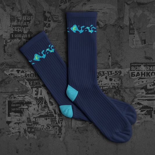 Blue socks with green designs on a textured dark background with 'NEW DROP' text.