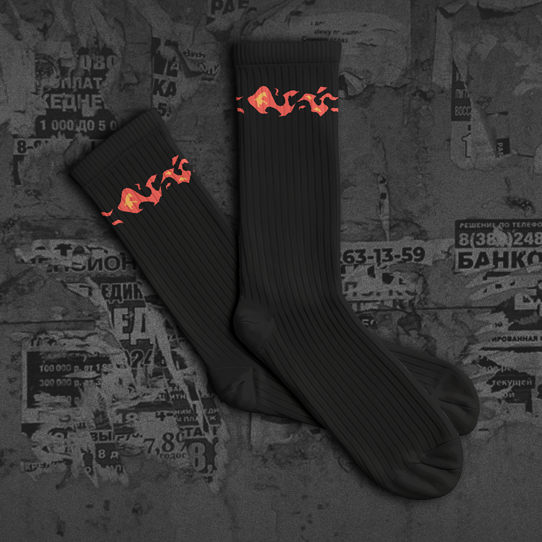 Black socks with red flame design on a textured background with 'NEW DROP' text.
